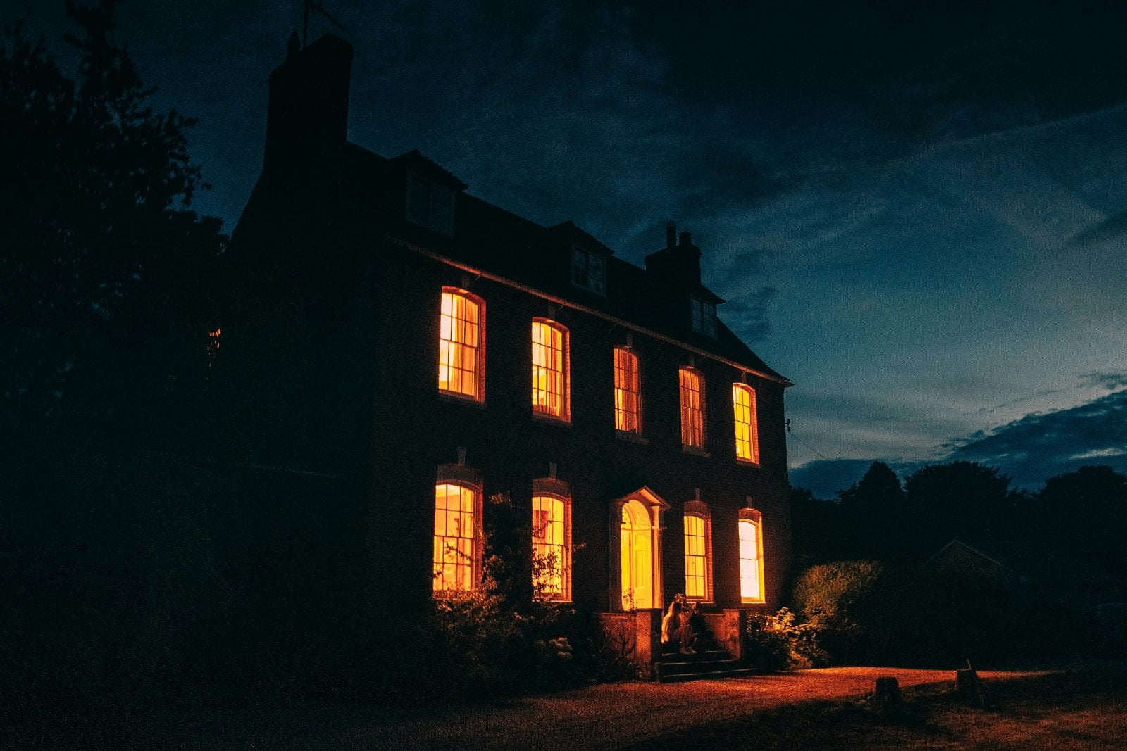 Historic brick manor house glowing at dusk