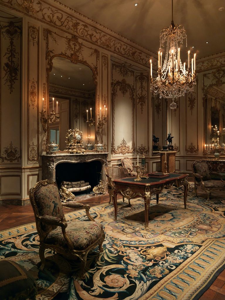 Paneled salon with carved marble mantel and crystal chandelier