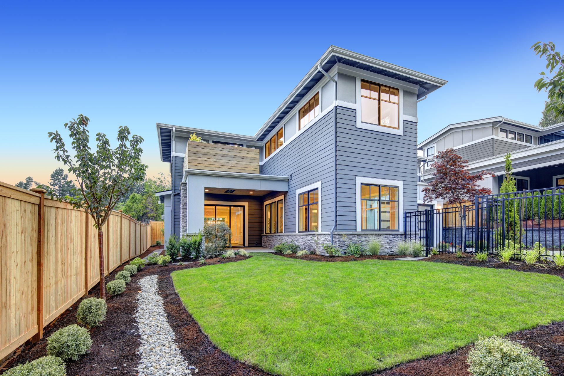 Exterior of grey blue craftsman style home with Welcoming backyard and covered patio. Northwest, USA
