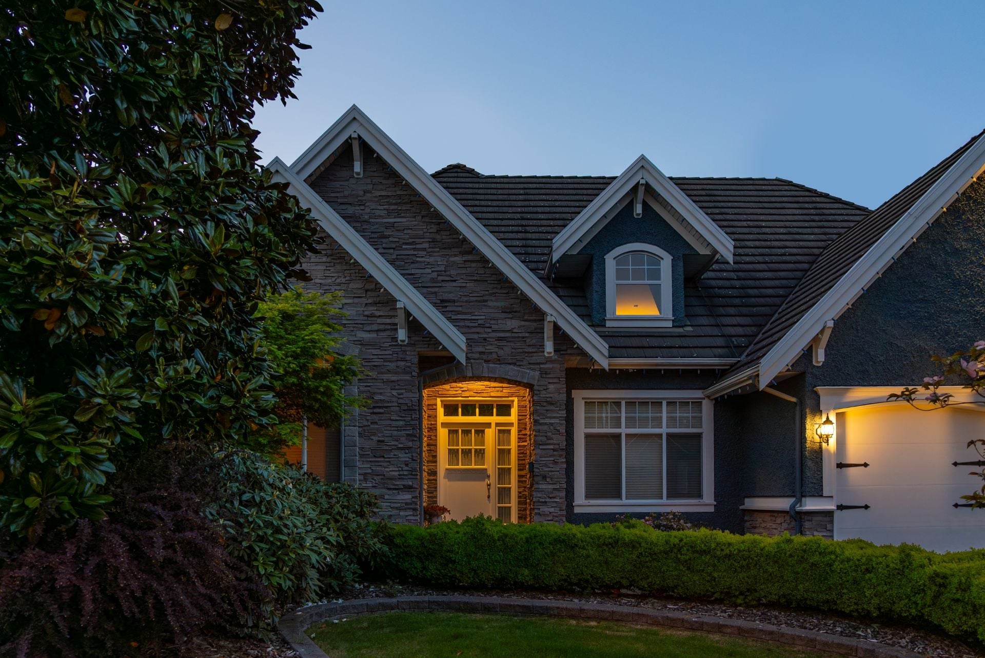 Two story stucco luxury house with nice Spring blossom landscape at night in Vancouver, Canada, North America. May 2025. 1