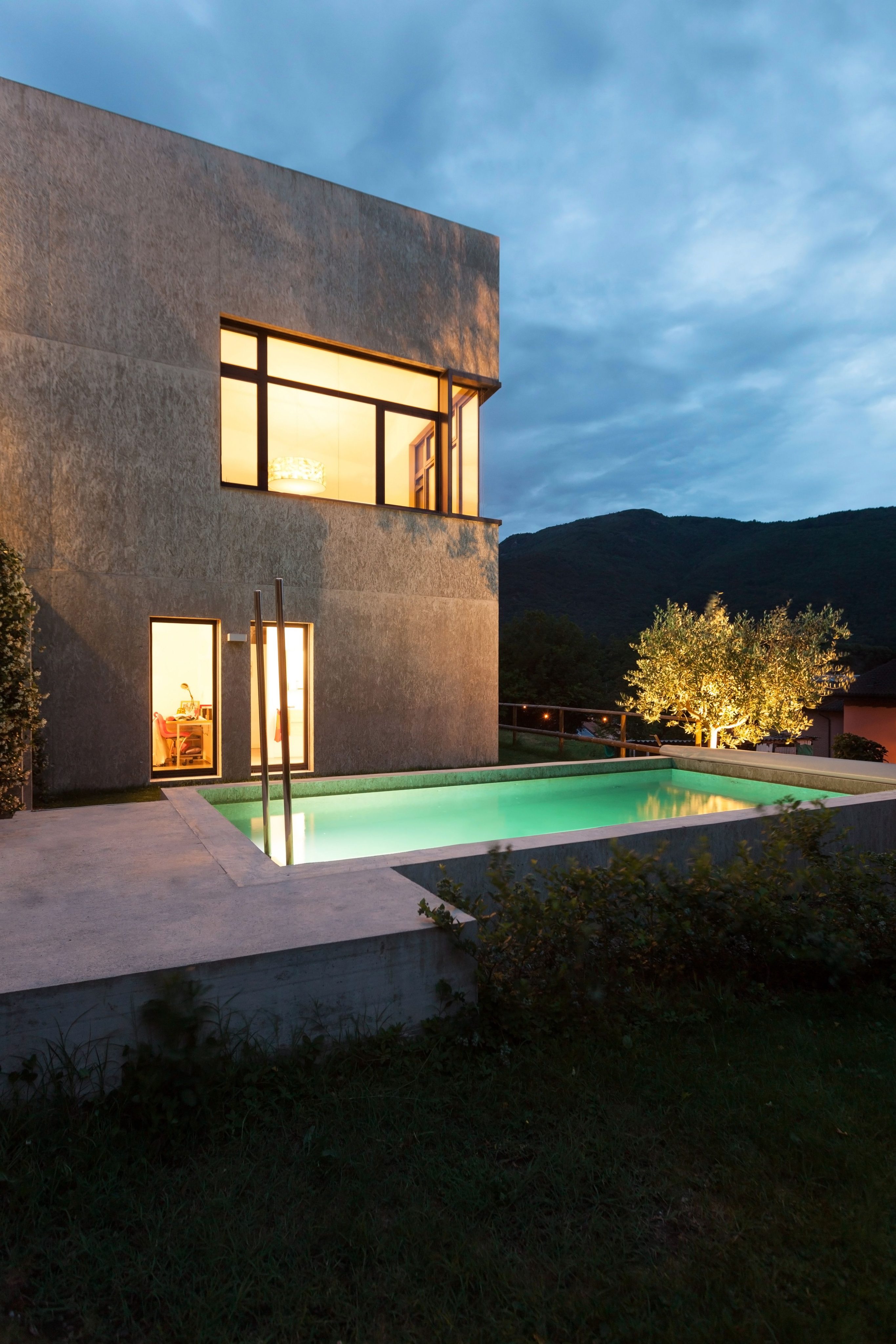 external of a modern house with pool, night scene