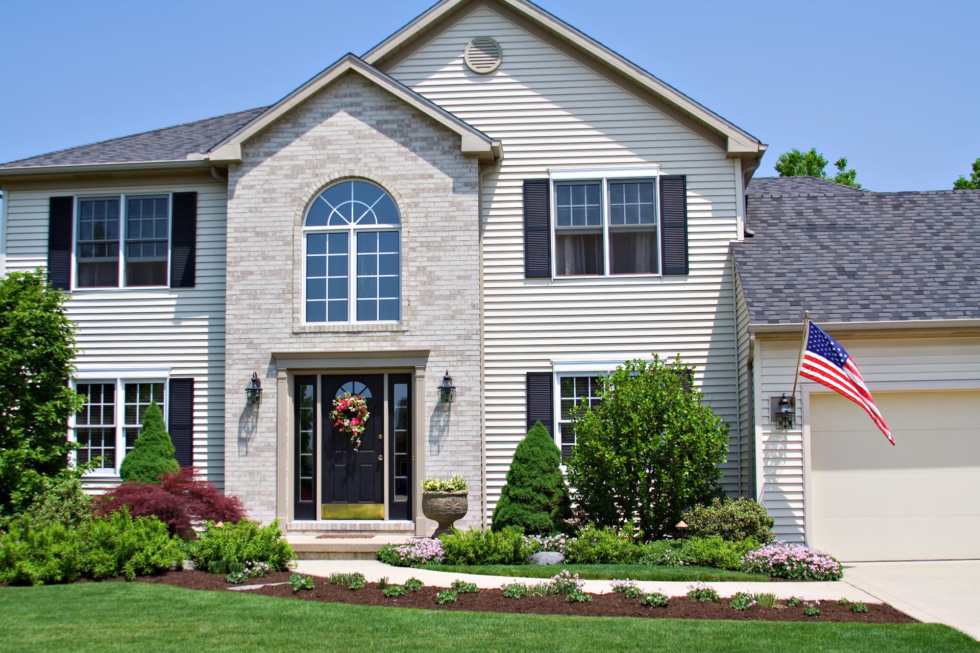 A beautiful neat suburban home in Ohio flying the American Flag.