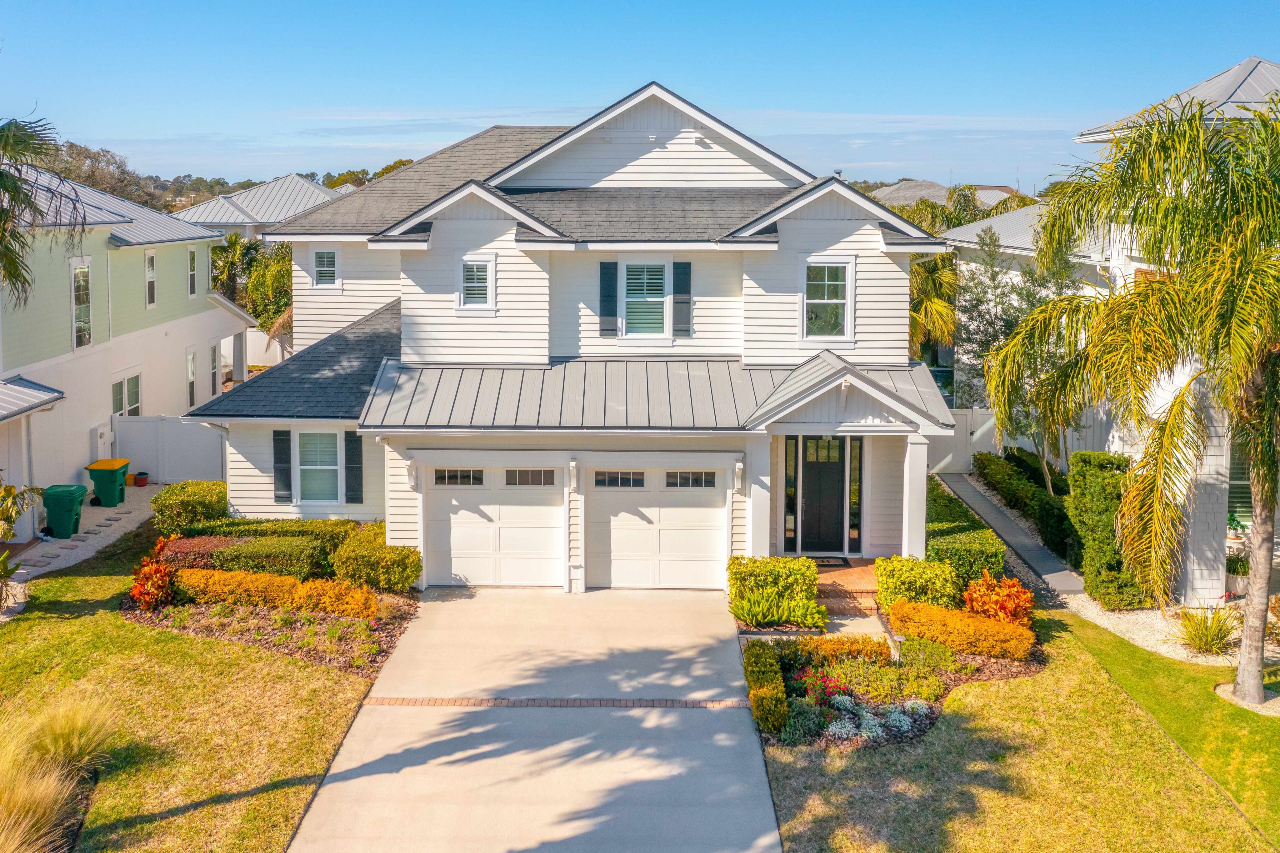 Aerial View of Luxury Coastal Home in a Palm Tree Lined Residential Neighborhood. It was a beautiful warm summer day shot during golden hour (sunset).