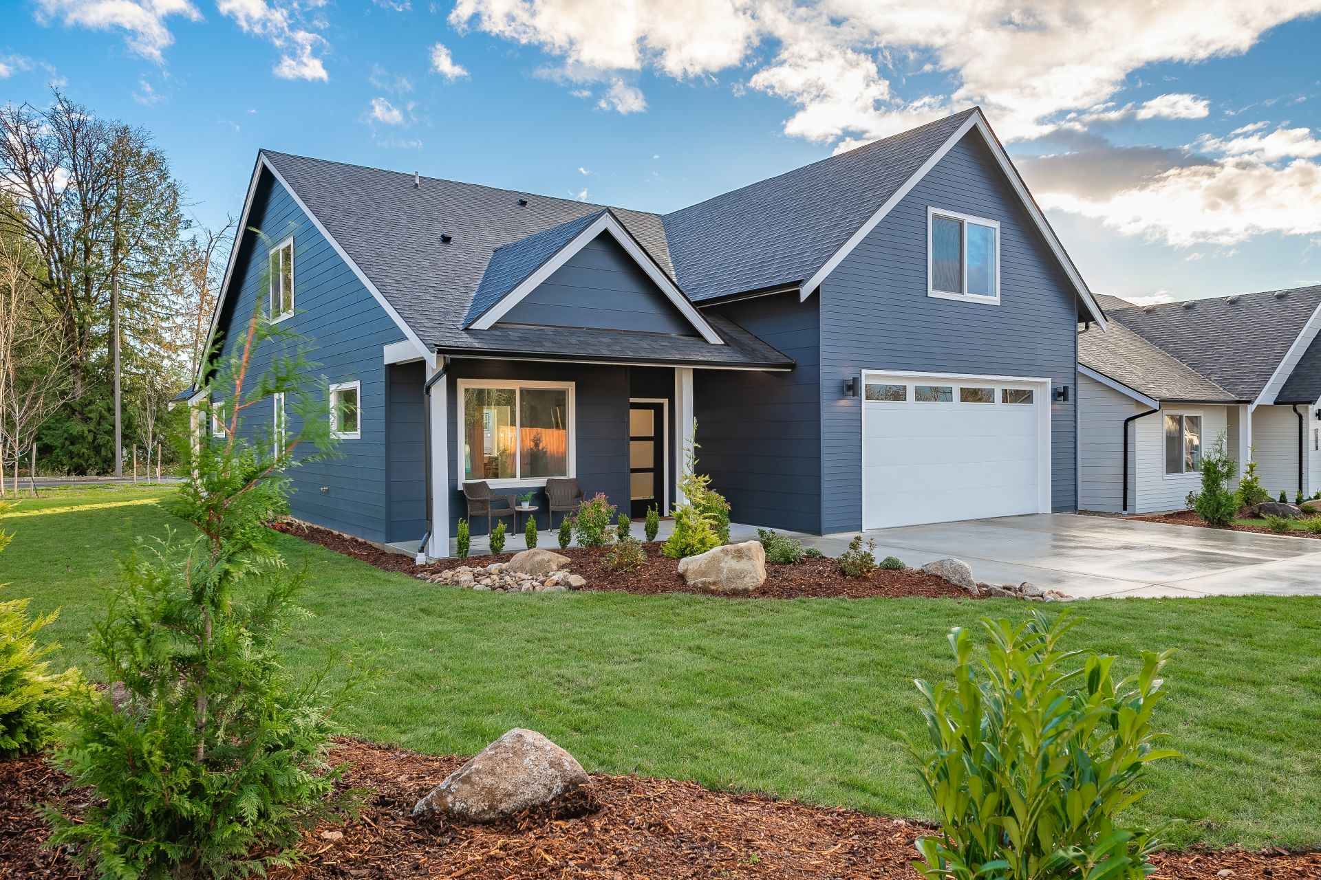 Middle class home exterior small rambler style house with simple style brand new construction blue sky green grass winter season family residence in a suburban neighborhood