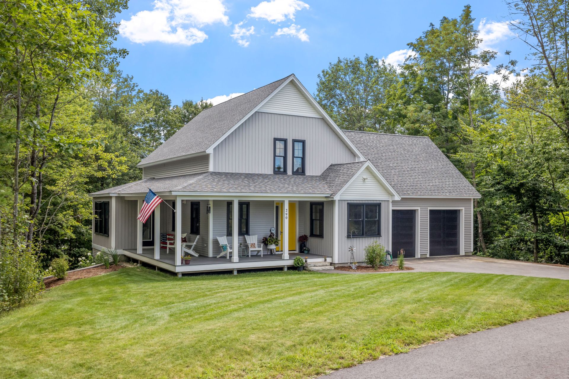 A modern custom new England colonial home with an American flag on a sunny day (1)