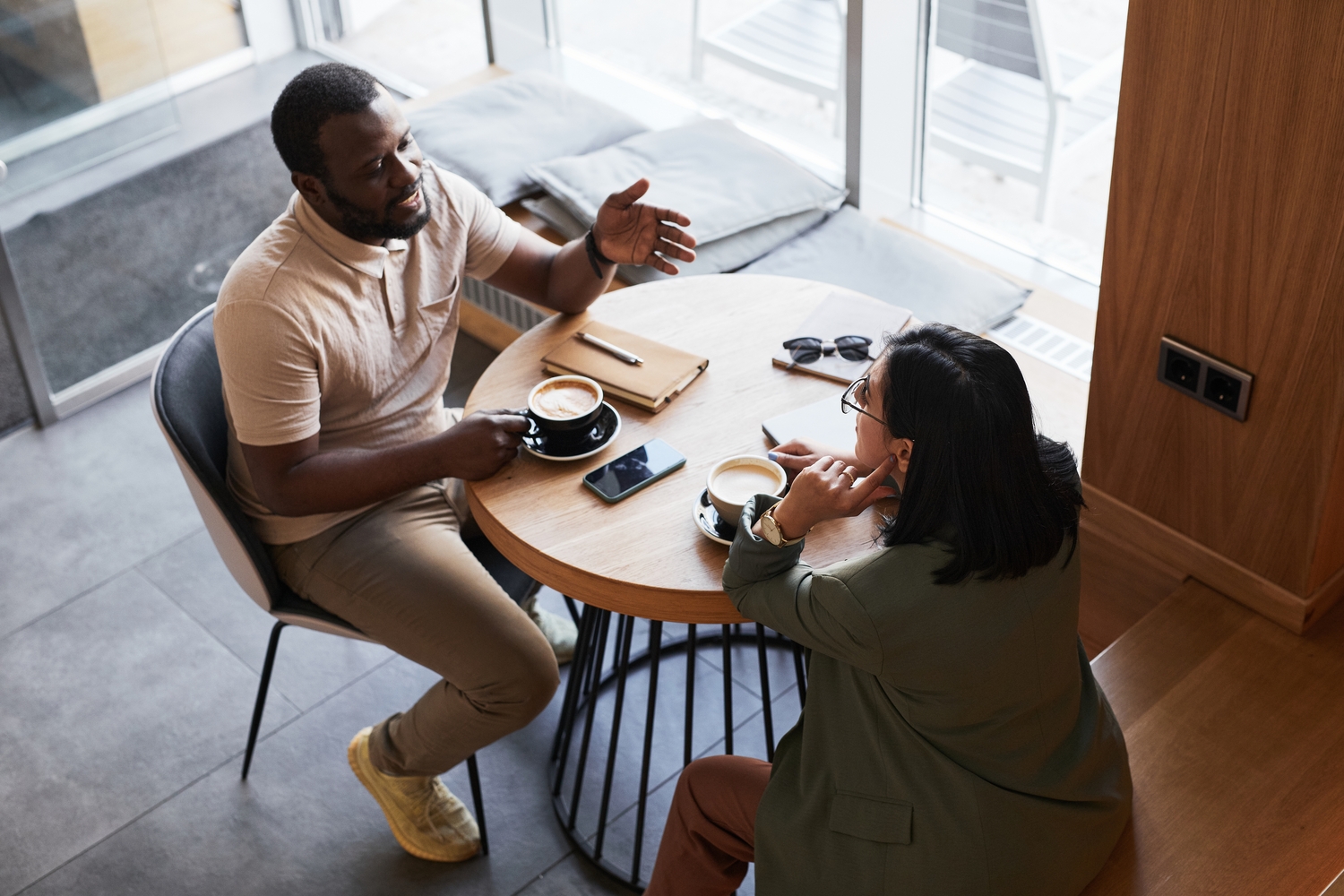 High,Angle,Portrait,Of,Two,Young,People,Chatting,At,Table