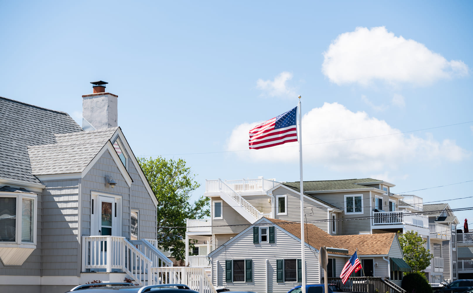 American flag waving in the wind in front of beach houses celebrating the 4th of July, Long Beach Island, NJ, LBI background