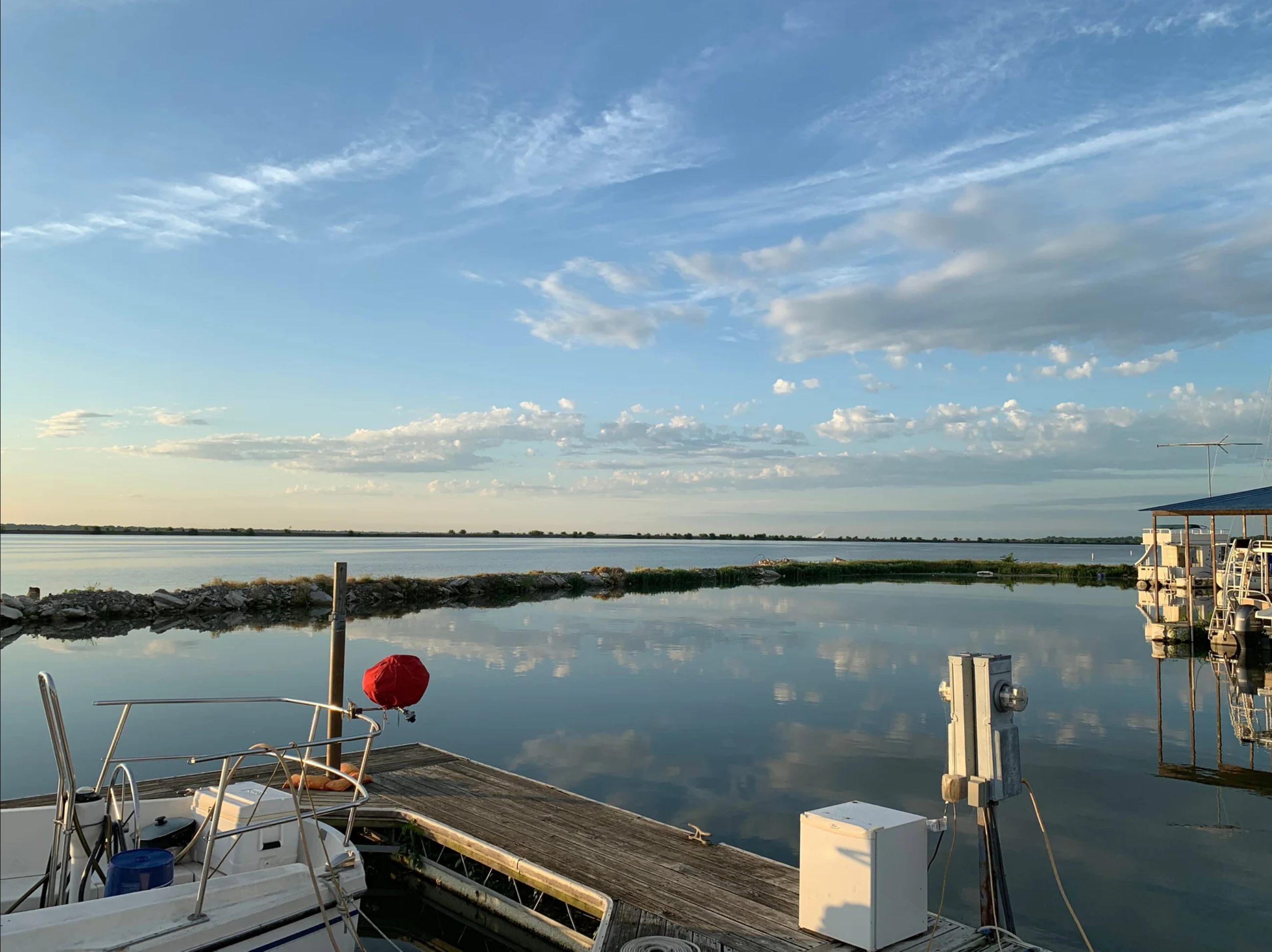 Boat dock on Lake Ray Hubbard with calm water and a marina in the distance at golden hour