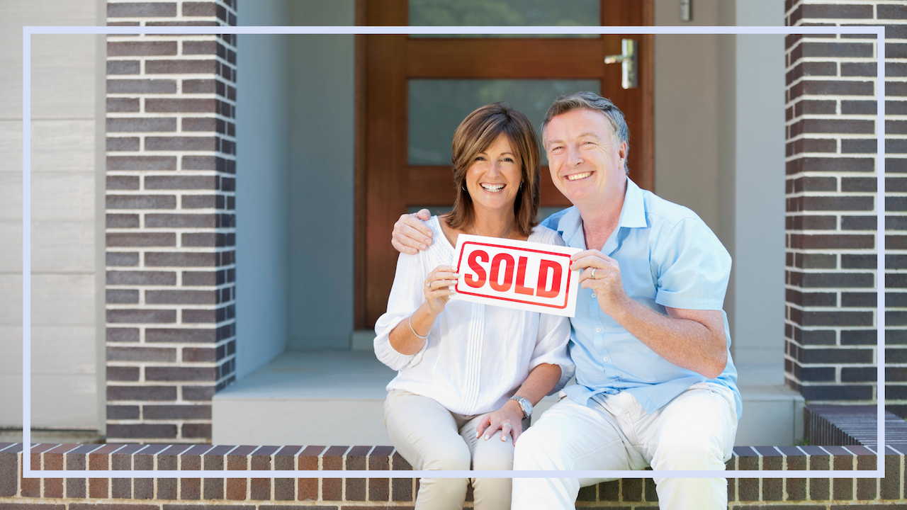Smiling couple holding a Sold sign in front of their home — Cindy Dunnican's Market Ready home selling guide