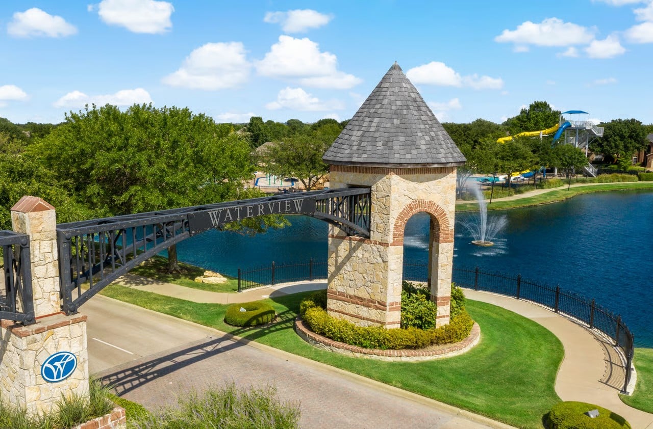 Waterview community entrance gate in Rowlett, Texas with lake and waterpark slides in the background