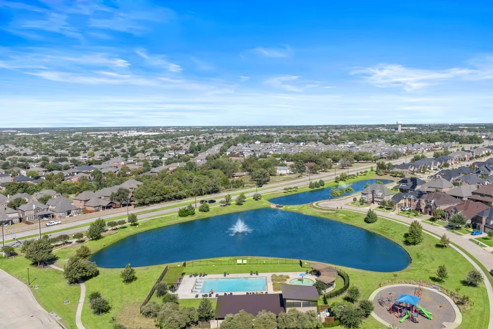 Aerial view of newer two-story brick and stone homes with fenced yards in Dominion of Pleasant Valley, Wylie, Texas