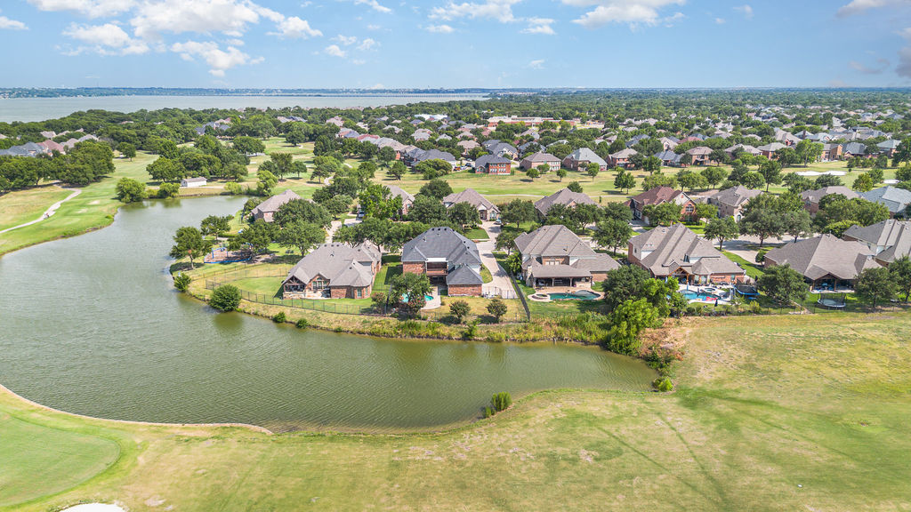 Aerial view of a golf course community in Rowlett, Texas with Lake Ray Hubbard in the distance