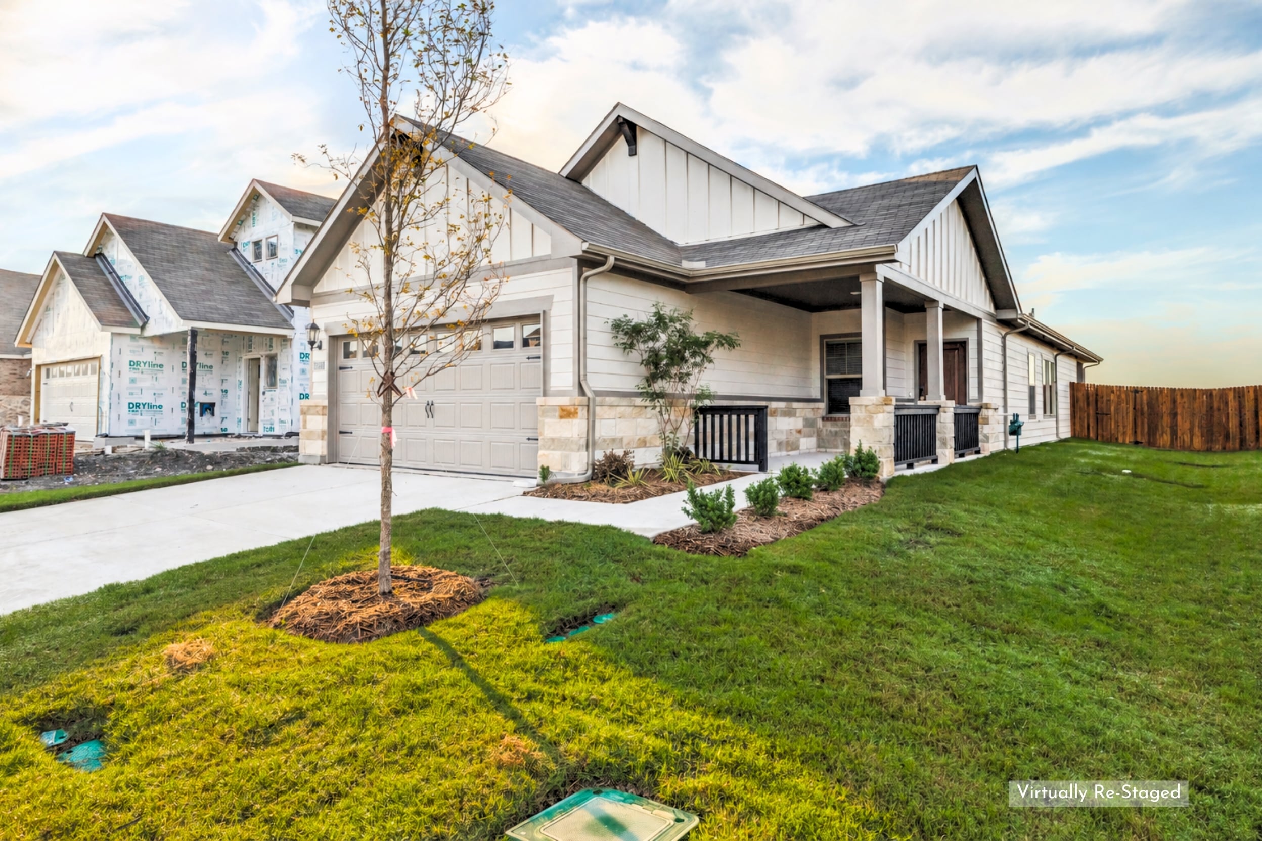 Single-story home with stone accents, a covered front porch, and a two-car garage on a residential street