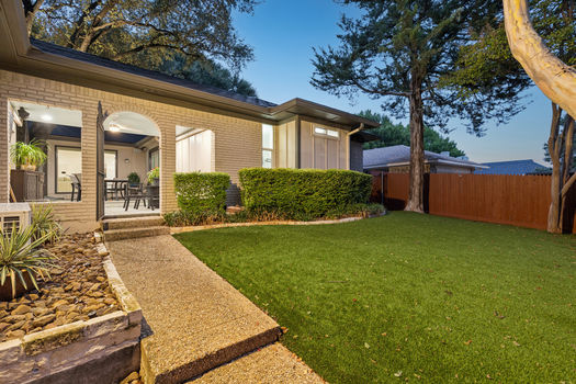 Backyard with covered patio and privacy fence at dusk | 9020 Glen Springs Dr, Dallas, TX 75243 | Lake Highlands