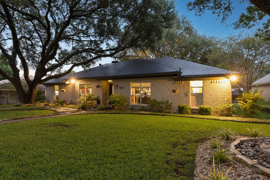 Front exterior at dusk with mature trees | 9020 Glen Springs Dr, Dallas, TX 75243 | Lake Highlands