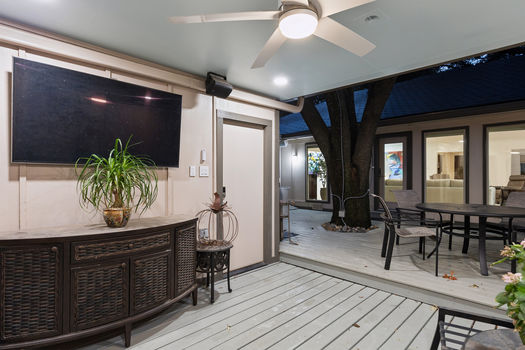 Covered patio with outdoor TV area at dusk | 9020 Glen Springs Dr, Dallas, TX 75243 | Lake Highlands