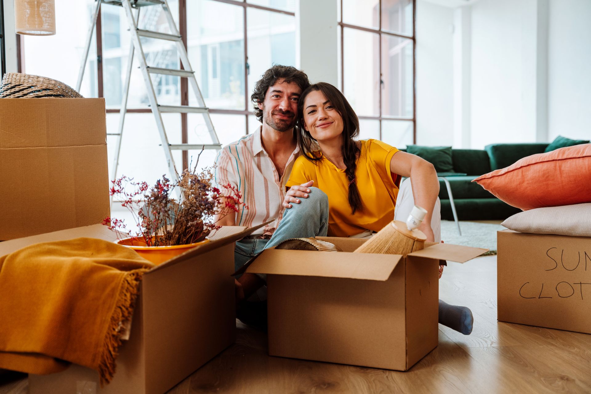 Happy young couple relocating in a new apartment. Young woman and man working and arranging the new property they just bought.