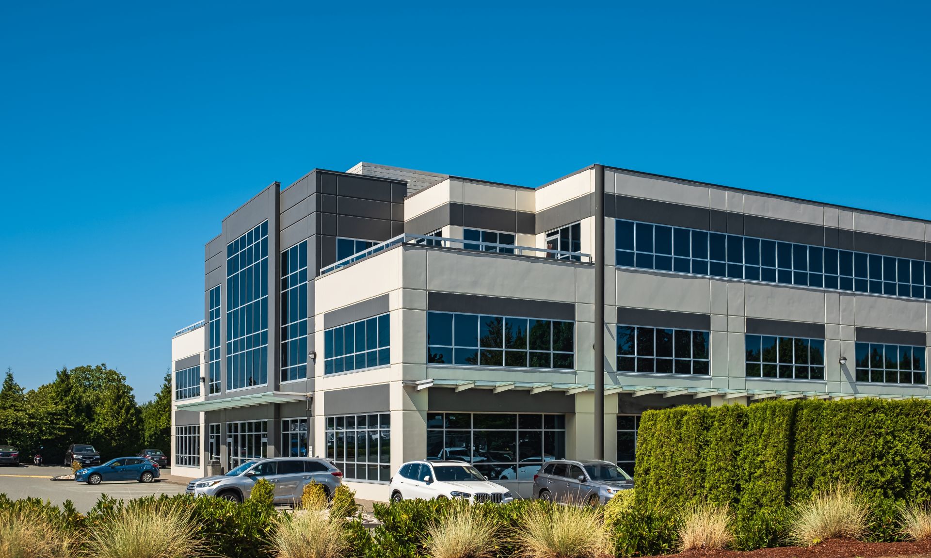 Modern suburban low rise office building. Architectural Exterior of Modern Low Rise Commerical Office Building Facade. Exterior of an office building with parking lot on a sunny summer day