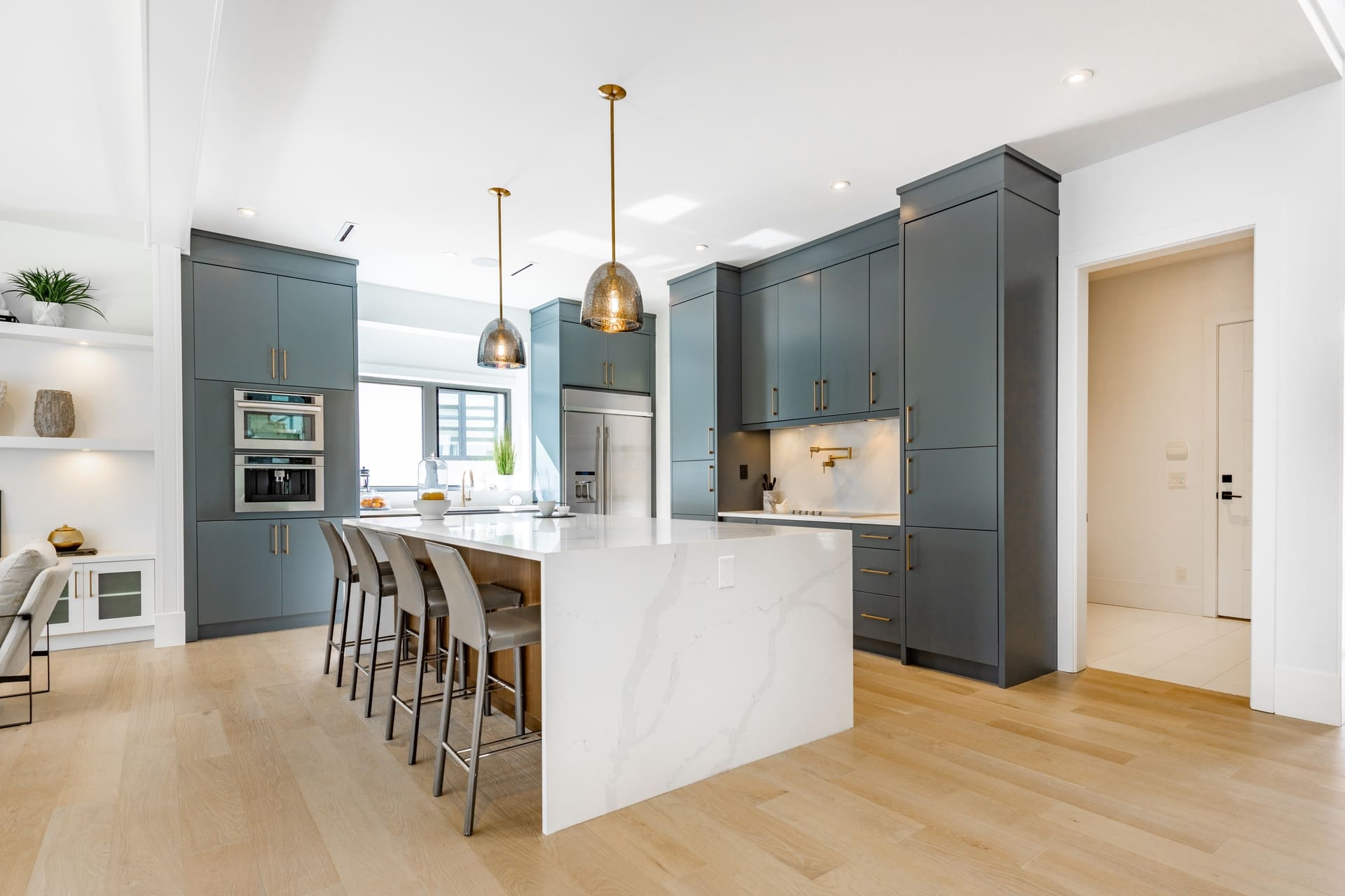 contemporary kitchen spice kitchen with grey cabinets white marble counter top sinks range appliances eating counter and pendant lights (3)