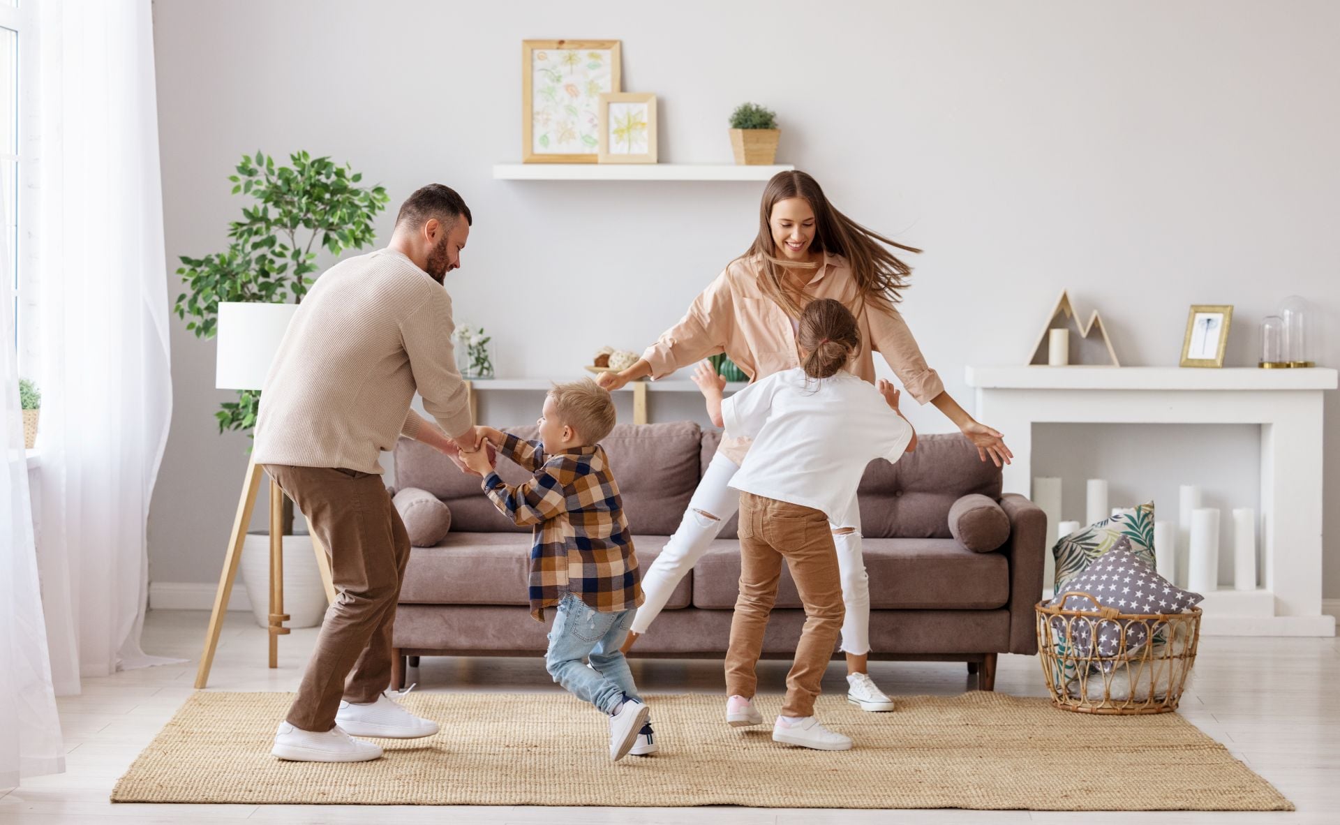 happy family mother father and kids daughter and son dancing and having fun at home