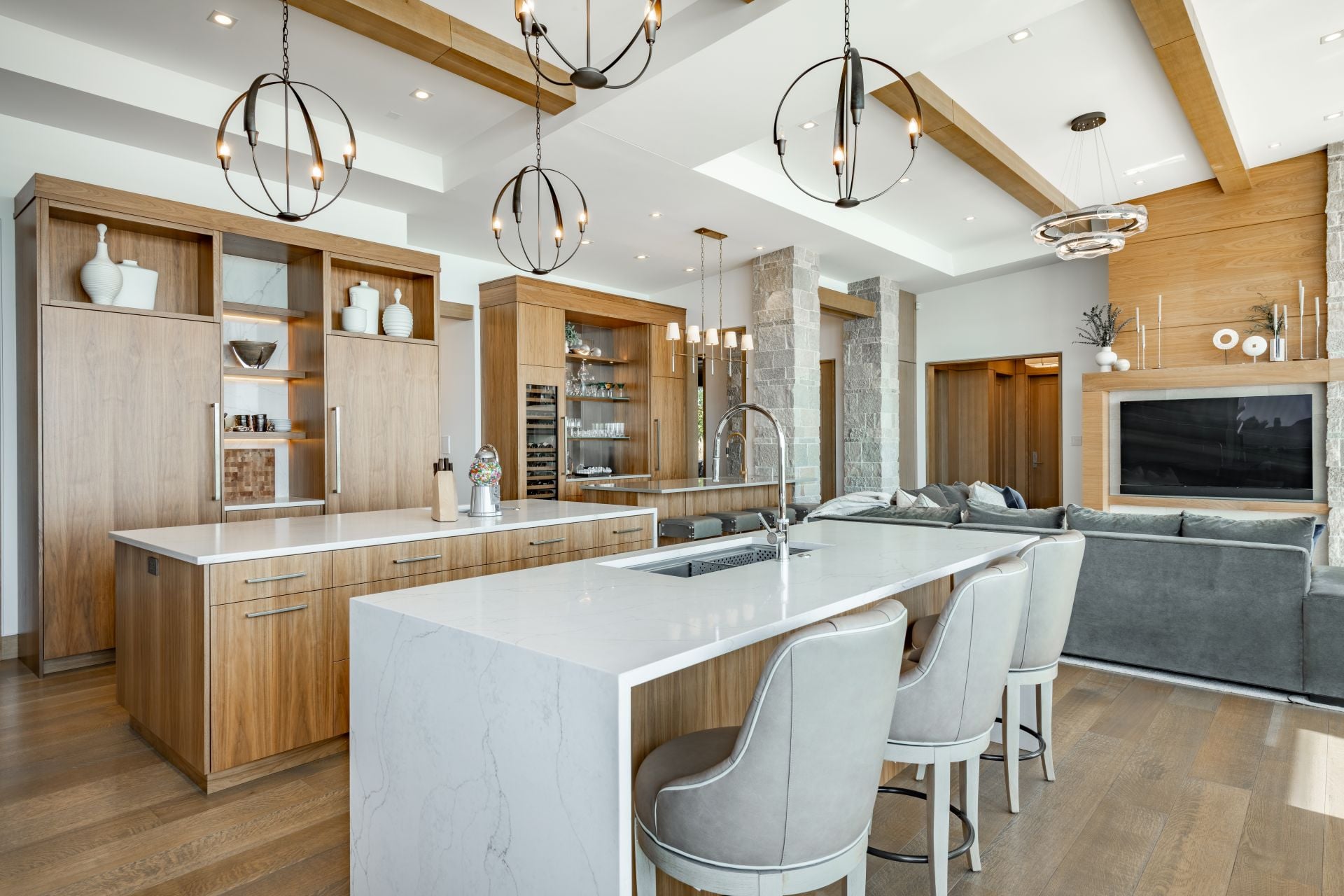 mountain modern luxury kitchen warm wood cabinetry large kitchen island home bar wet bar stacked stone columns interior light floors exposed ceiling beams