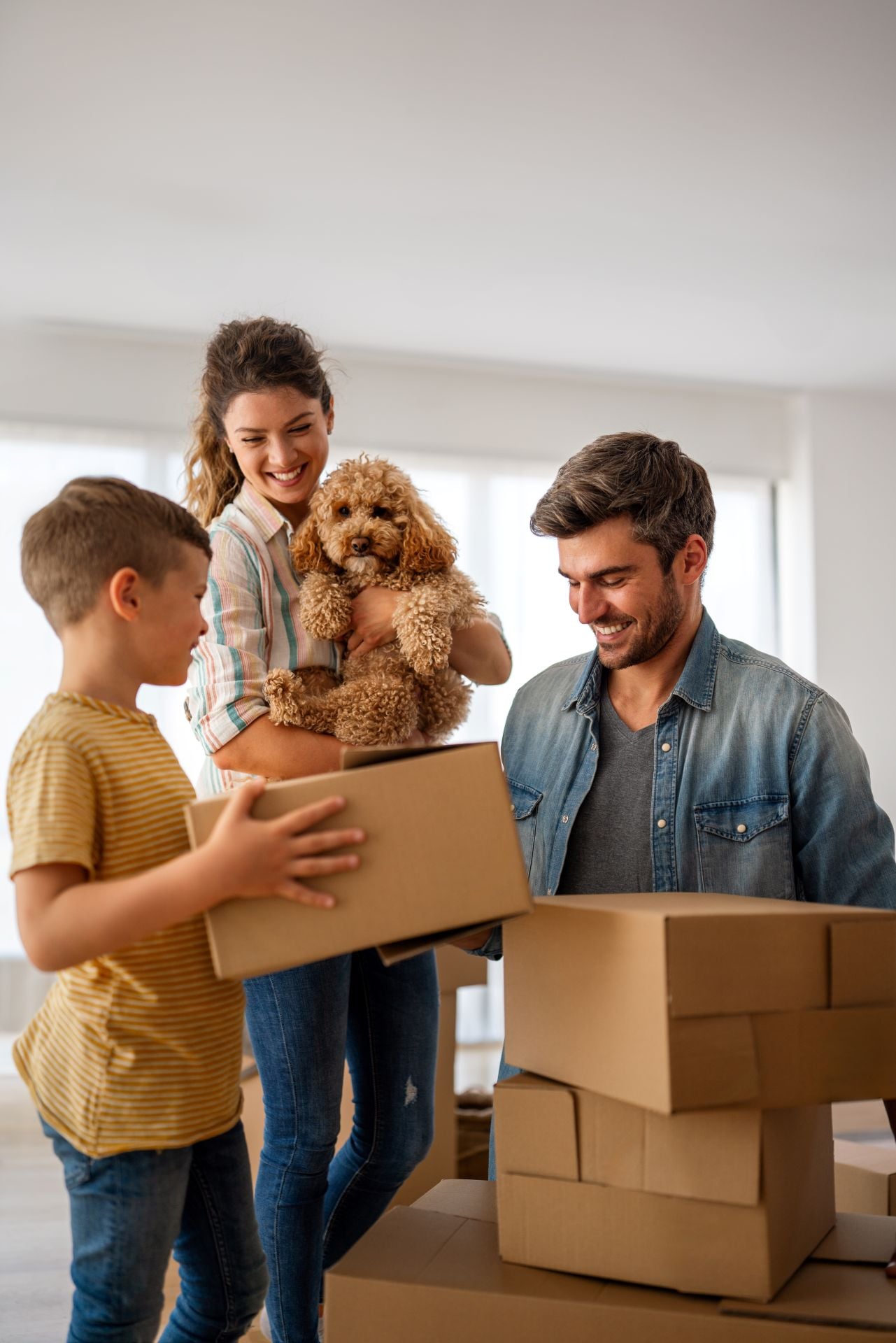 Happy family with cardboard boxes in new house at moving day. Mortgage, family, real estate concept