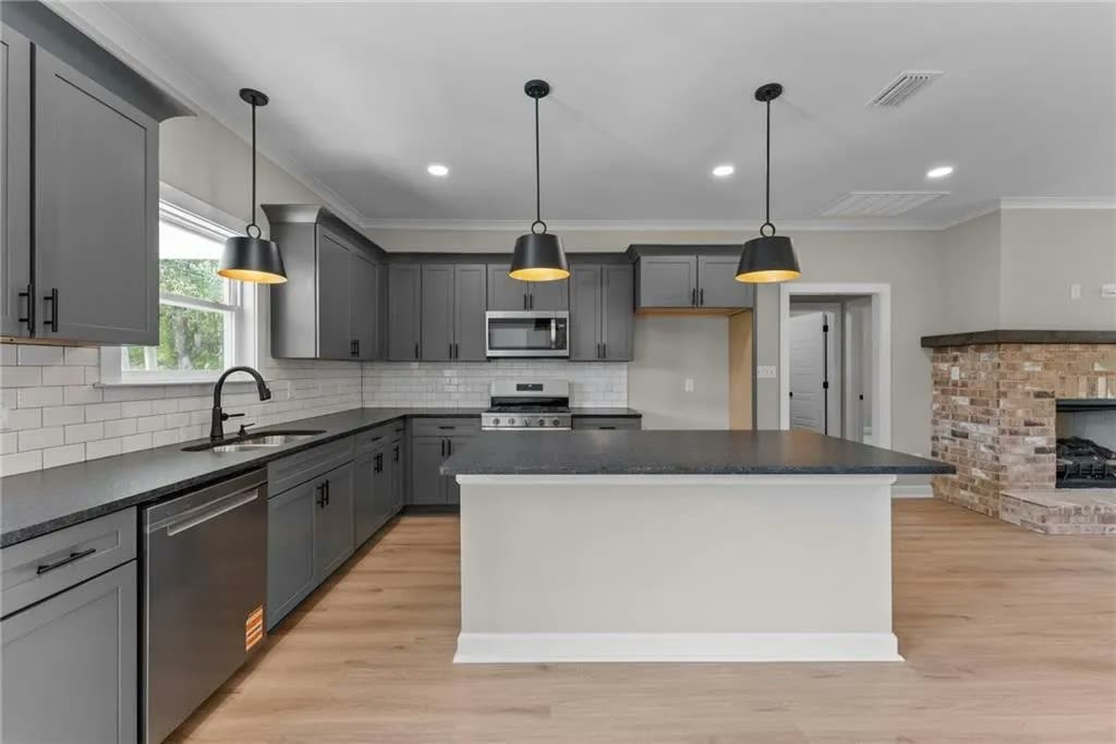 Kitchen with gray cabinets and a large island in the Border Drive new construction home