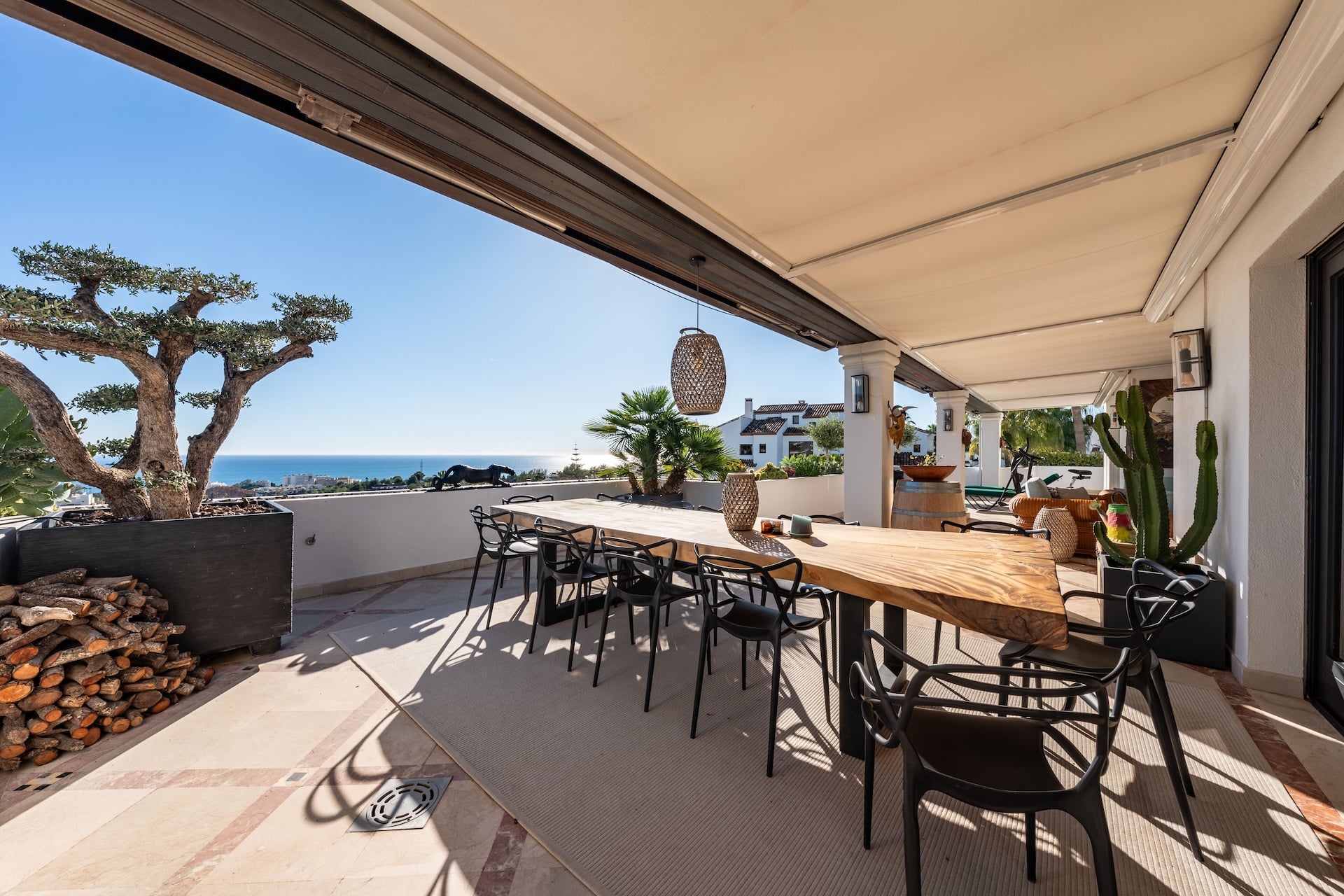 Luxury Outdoor Dining Patio with Sea View and wooden dining table in mediterranean penthouse