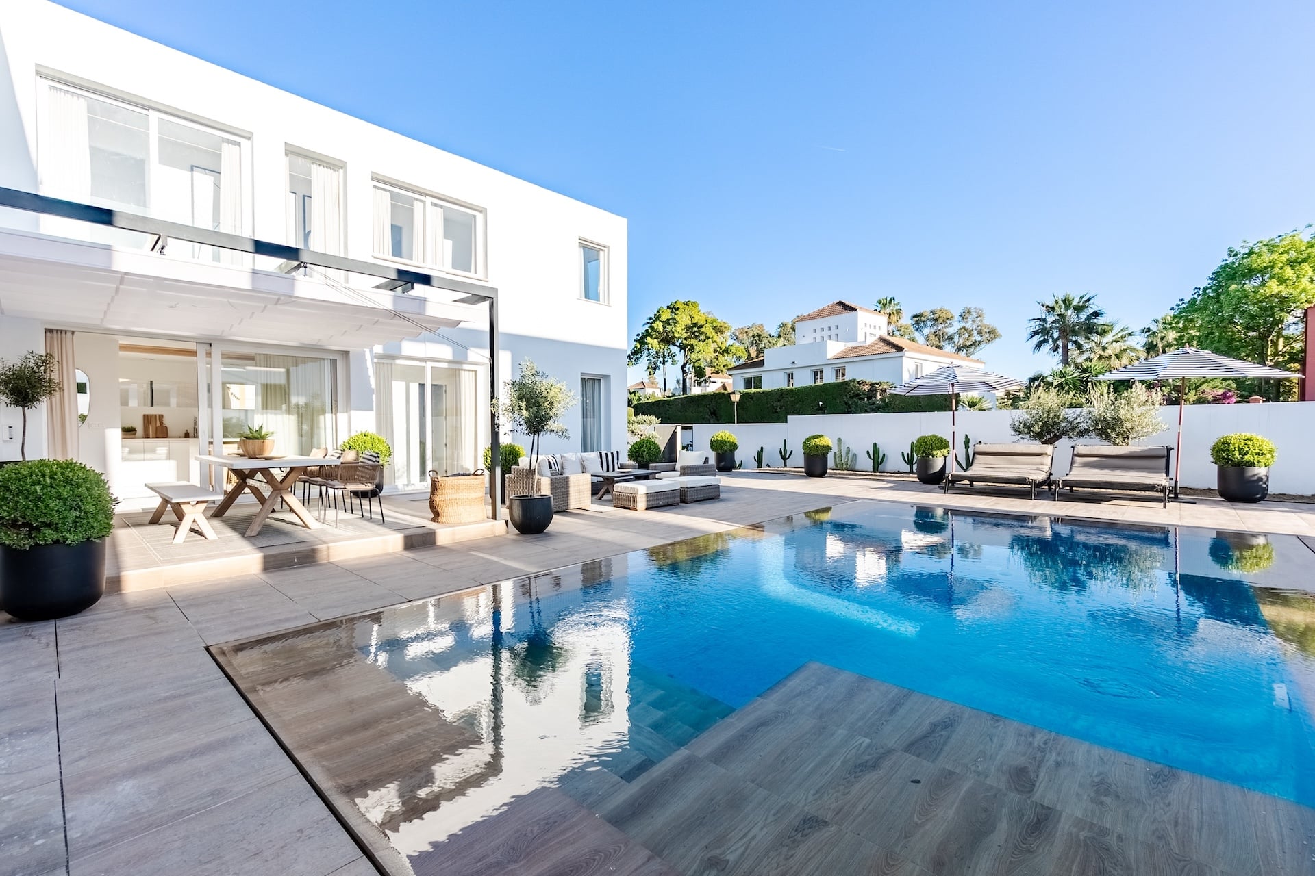 a luxurious mediterranean mansion garden with various seats and infinity pool