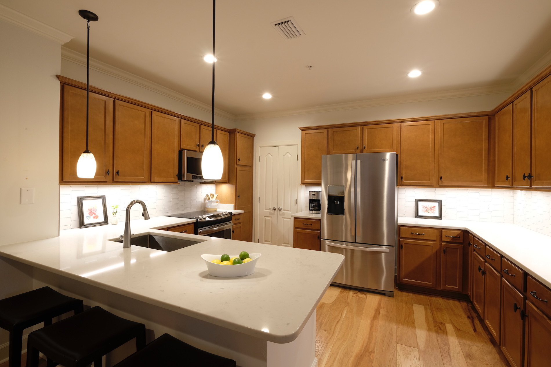 Renovated kitchen, white quartz counters, stainless appliances, light pendant