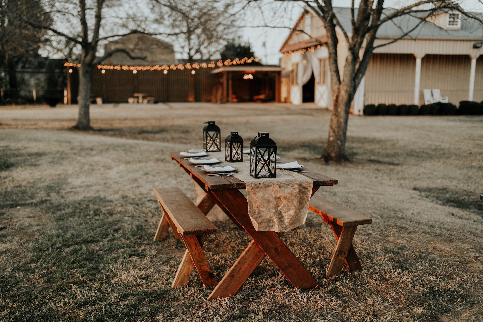 picnic table decorated for outdoor gathering with string lights