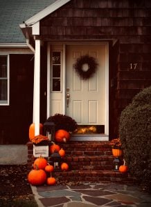 fall porch with pumpkins and mums