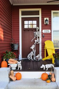 fall porch with pumpkins and skeletons